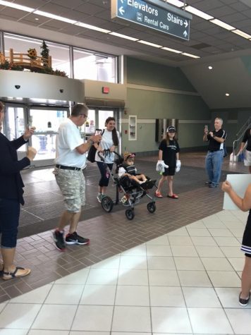 Make-a-Wish recipient Alia and her mom arrive at the airport to find signs and cheers from cheerleaders of all ages as part of their send-off to Disney World. 