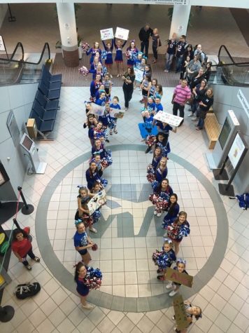 The Londonderry Cheerleaders, ECE cheerleaders, and the Blue Lions wait in the airport for Make-a-Wish-recipient Alia to arrive. The cheerleaders made signs, so Alia's send-off to Disney World would be filled with fun and cheers.