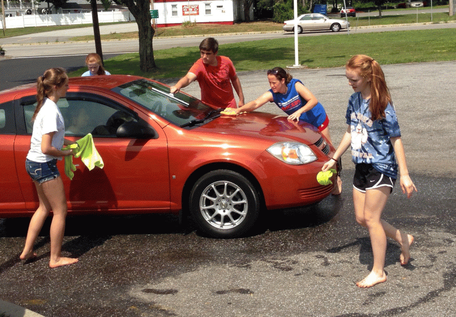 Juniors Shea Robinson, Emily Vetros, Logan Wright and 2017 class adviser Mrs. Bouchard work together to help make their classs car wash this past summer a success.