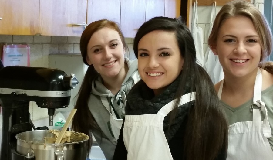Junior Hannah Donahue  and seniors Shelbi Pincence and Julia Sorrell take turns using the mixer as they make a homemade pie during culinary club.
