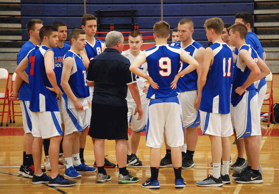 Coach Vaughn helps prep the boys volleyball team during their game against Souhegan on May 23.
