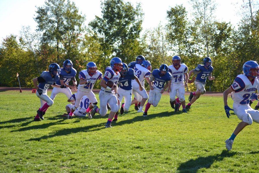 Tyler Kayo breaks away from Merrimack defenders in their 49-6 win. 