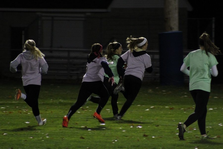 Junior Halle Hamilton (in the green) races past a couple of sophomore defenders the juniors victory over the 10th graders. 