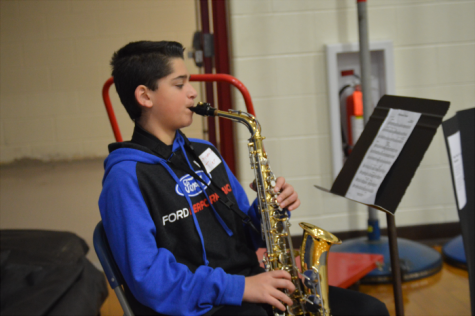 Freshman Tyler Fauc scans his music sheets as he plays his own saxophone.