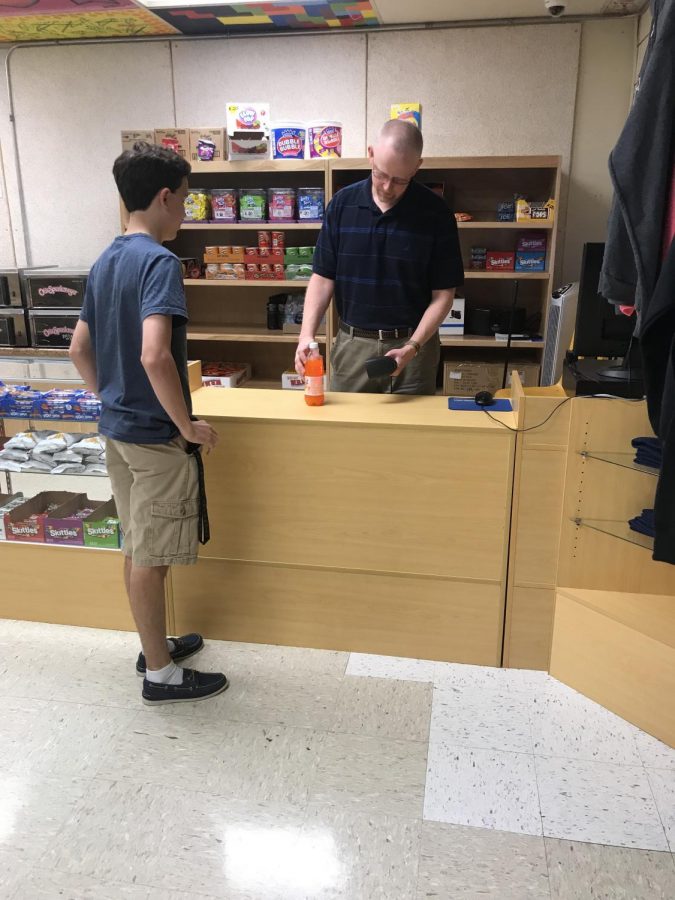 Mr. Greene, manager of the Lancer Locker, checks out senior Tyler Dupuis. The Lancer Locker expanded their selection tremendously this year.