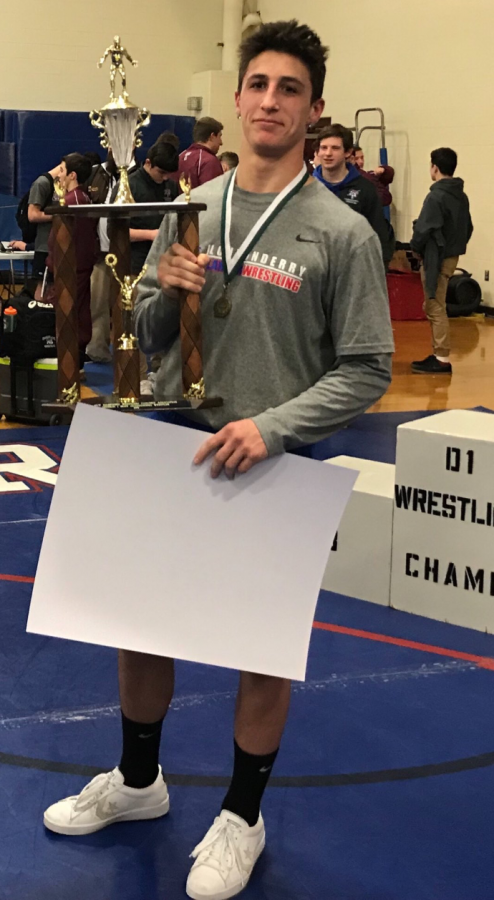 Santos raises his Most Outstanding Wrestler trophy after his big win