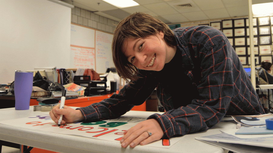 Abigail Whitcomb puts the finishing touches on a poster for the seminar.  