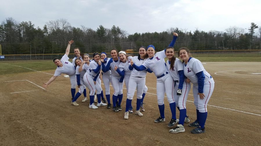 The+girls+softball+team+gathering+together+for+a+picture+at+home+plate+before+a+home+match.