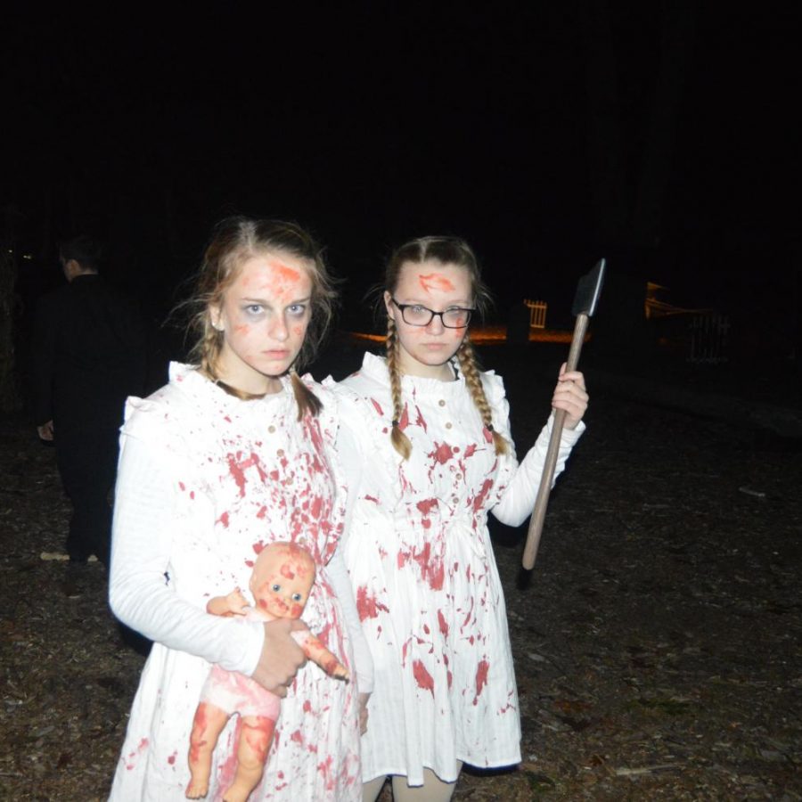 Sophomores+Gabby+Page+and+Evie+Burnette+stare+at+walkers+in+an+attempt+to+scare+them+as+they+travel+through+the+Haunted+Woods+at+last+year%E2%80%99s+performance.+%0A%0A