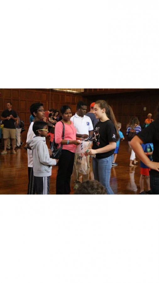 Connor talks to a family about about FIRST and STEM at an event called Touch Tomorrow. 