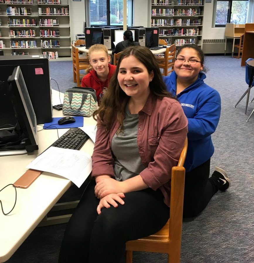 Club members Maya Lincoln, Marie Duffy, and Haley Hines research in the library during a meeting.
