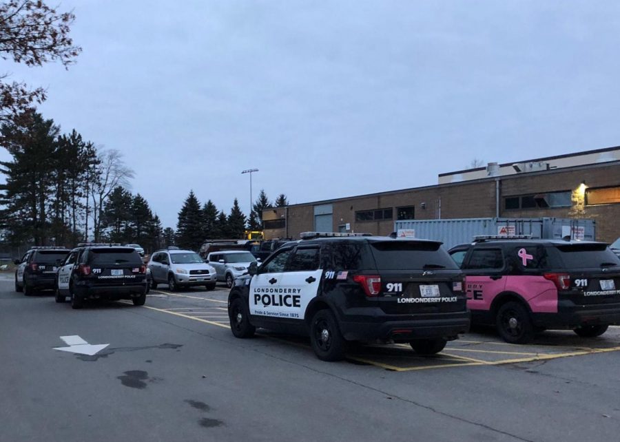 Four police cruisers were parked behind the school, with about six officers reported as sweeping the building and handling the situation.