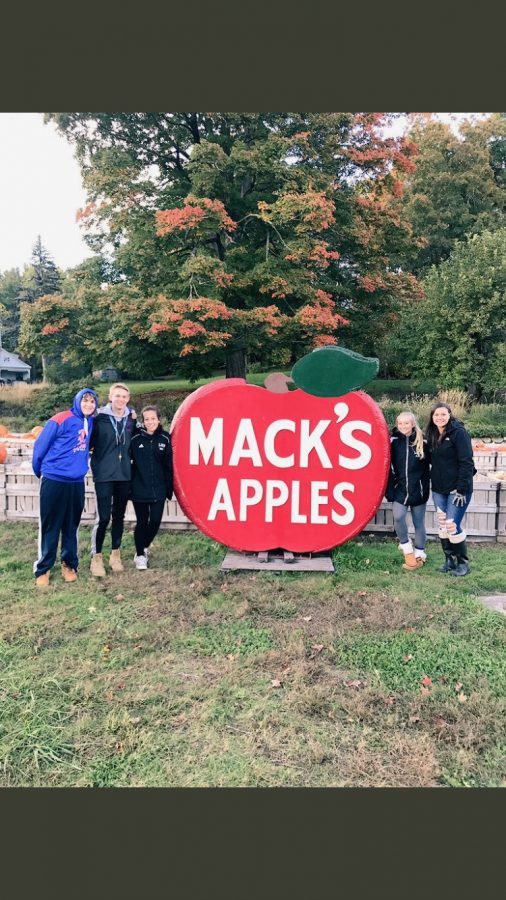 Students from the class of 2020 stand next to the Mack’s Apples sign at a recent class event. 