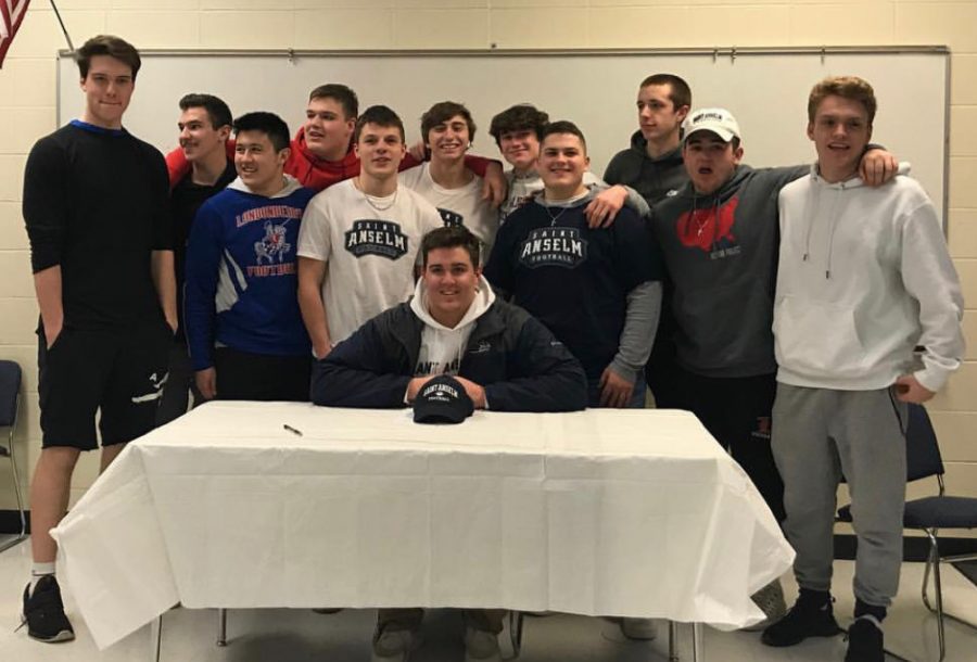 Friends surround Berube as he signs off on his commitment to Saint A’s college for football.
