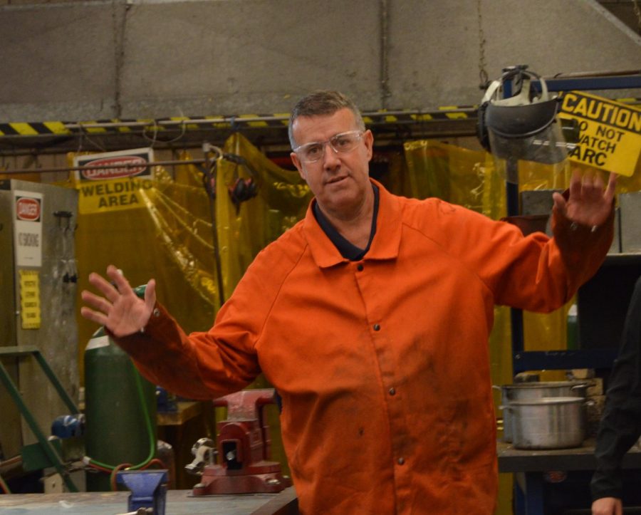 Last years Teacher of the Year, Mr. Decloux, poses for a photo during his metals class.