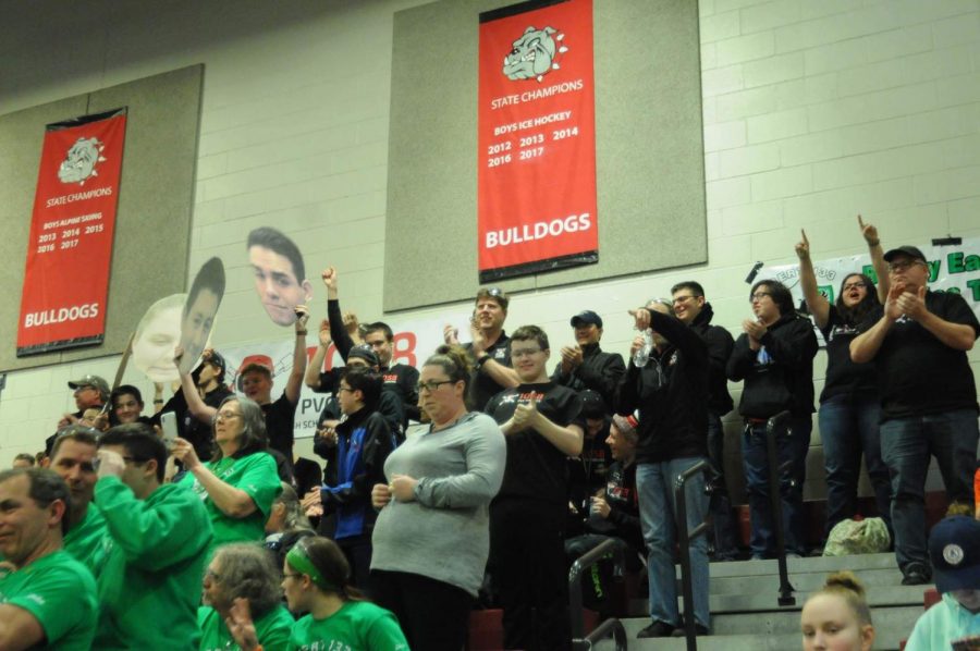 The team celebrates winning their first match of the day. Every year, to encourage the drive team they print large cutouts of their heads.