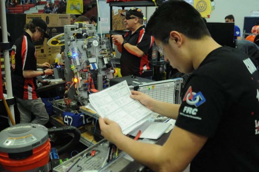 Zack Chau looks over robot data provided by scouters. Scouters watch the field the whole day and take down important information about every robot.