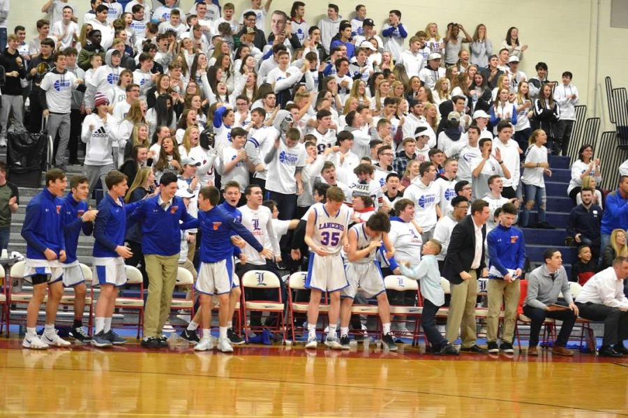 Fans+stand+up+for+a+whiteout+game+to+support+the+boys+basketball+team+in+their+quarterfinal+matchup.