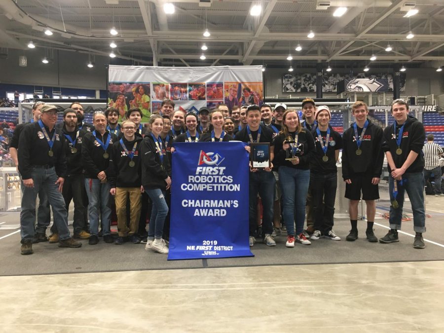 The robotics team poses with The Chairmans Award, after winning it at their last competition.