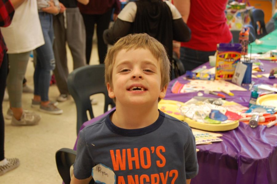 Ryan smiles as he finishes his craft. Ryans favorite part of the day was the treasure hunt because he liked finding the buckets that had treasure in them.