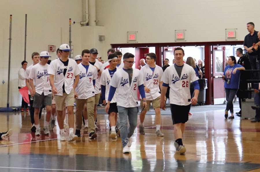 The varsity baseball team strolls onto the gym floor at the recent spring pep rally.