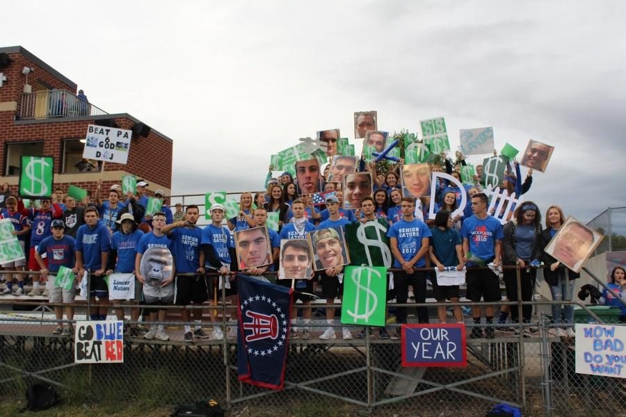 Senior Gators prepare the swamp with blown out pictures of athletes and the football team’s signature money signs ahead of Mack Plaque football game. 