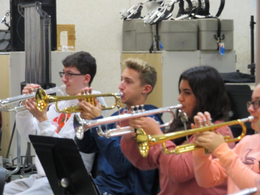 Senior Ryan Cullen and juniors Brandon White and Amara Cote practice their halftime music in band class. 