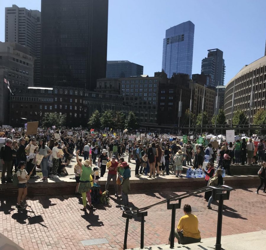 Protesters gather in Boston with their signs to protest the change in climate.