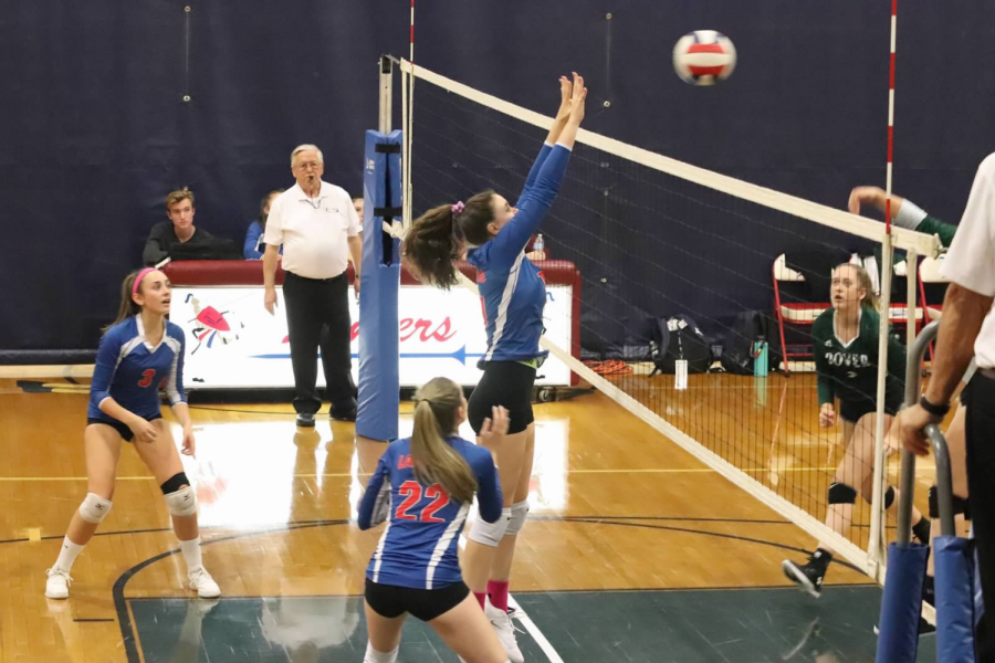 Junior Katrina King blocks a strong hit against Dover volleyball team.