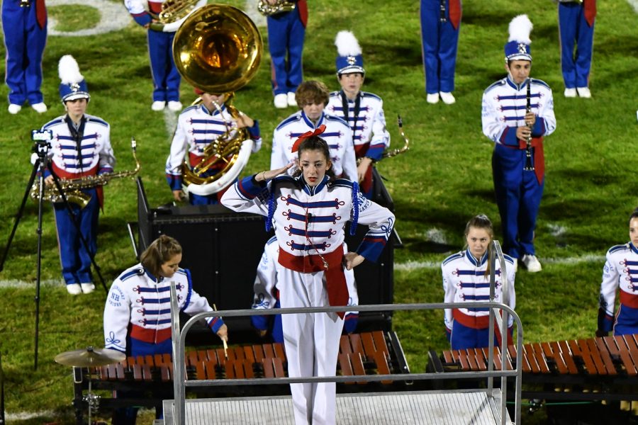 Senior Eliana Patterson salutes to the crowd during halftime at a home game. 