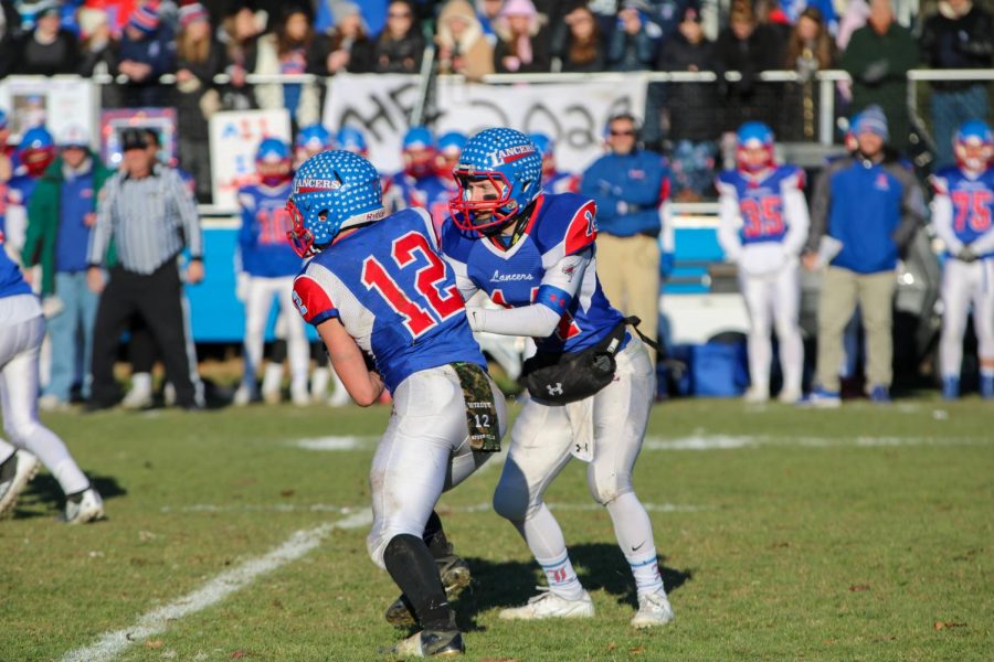 Quarterback+Jake+McEachern+hands+the+ball+off+to+running+back+Jeff+Wiedenfeld.+The+Lancers+defeated+Salem+in+the+Division+One+Semifinals+and+advanced+to+the+state+championship.