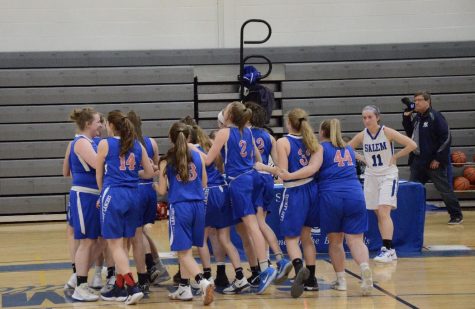 The girls stand in a huddle as they prepare for their game against the Salem Blue Devils. 