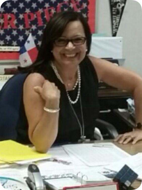 Carasquillo leans on her desk in the main office.
