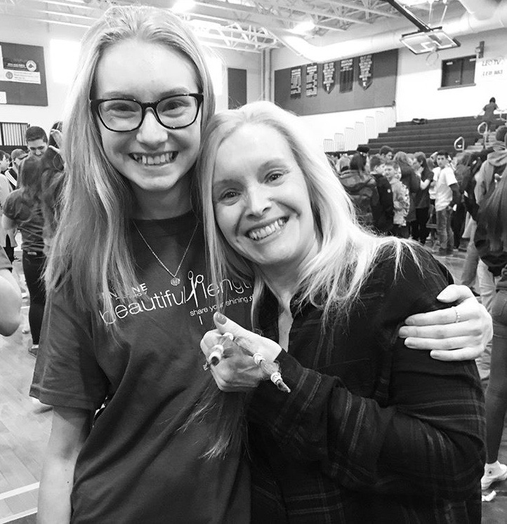 LHS substitute teacher Erin Mosher holds the scissors she will use to cut her daughter Hailey's hair at the Day of Giving Assembly in 2018. Hailey donated her hair to honor her cousin who had survived breast cancer the previous year.