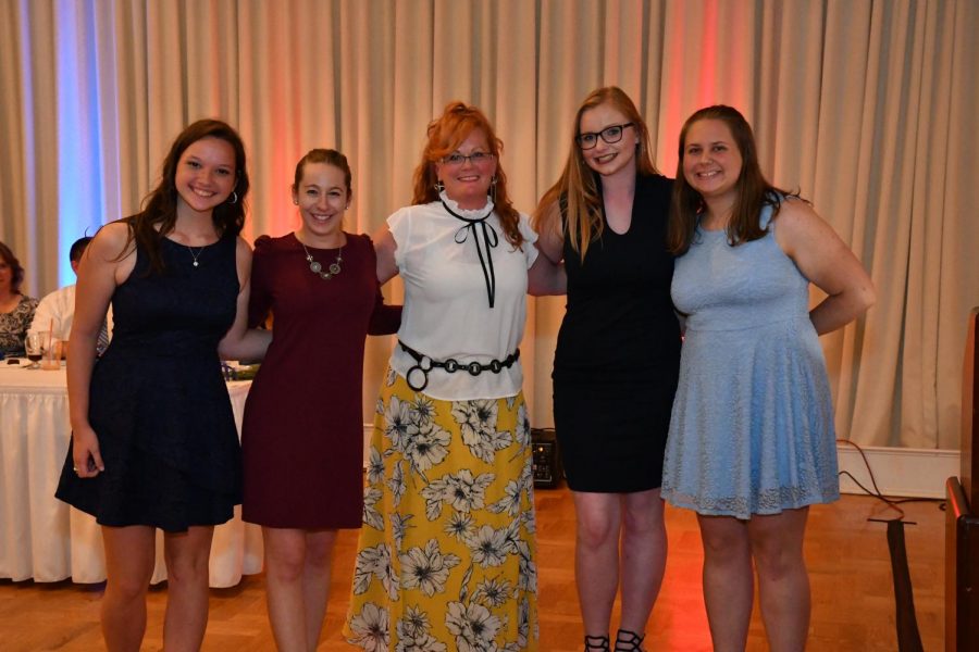 Horne poses for a picture with past and present Colorguard members at banquet.