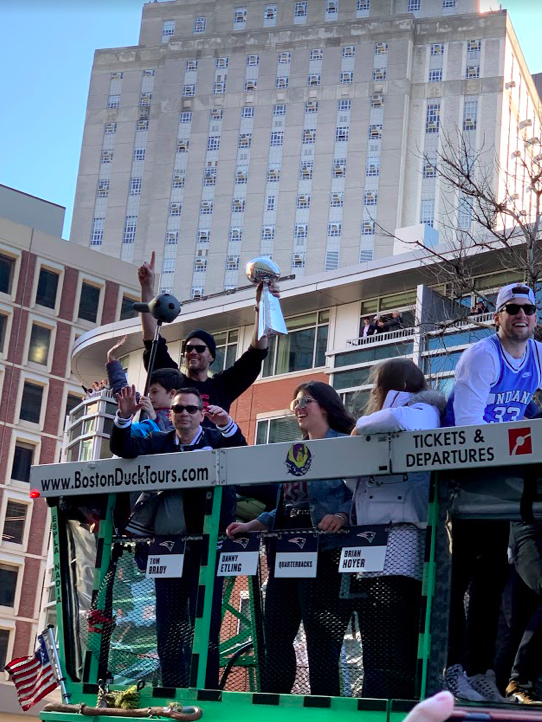 Tom Brady carrying the Lombardi trophy during the Super Bowl parade in Boston.