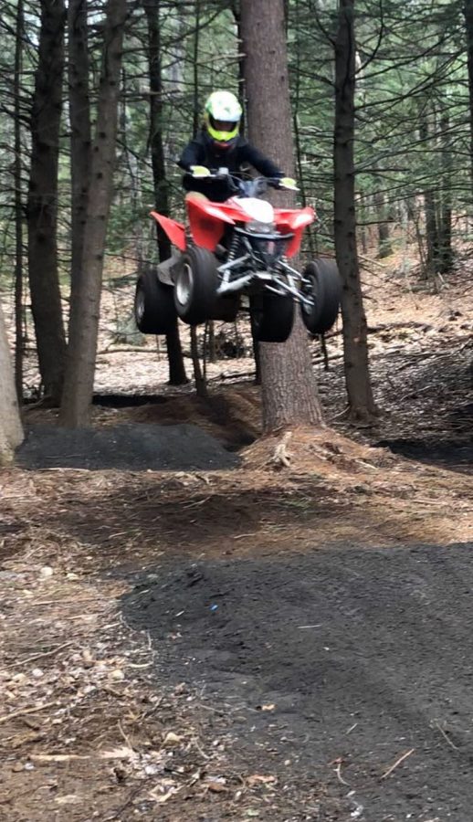 Junior Dylan Barnes rides four wheeler through trails in the woods. 