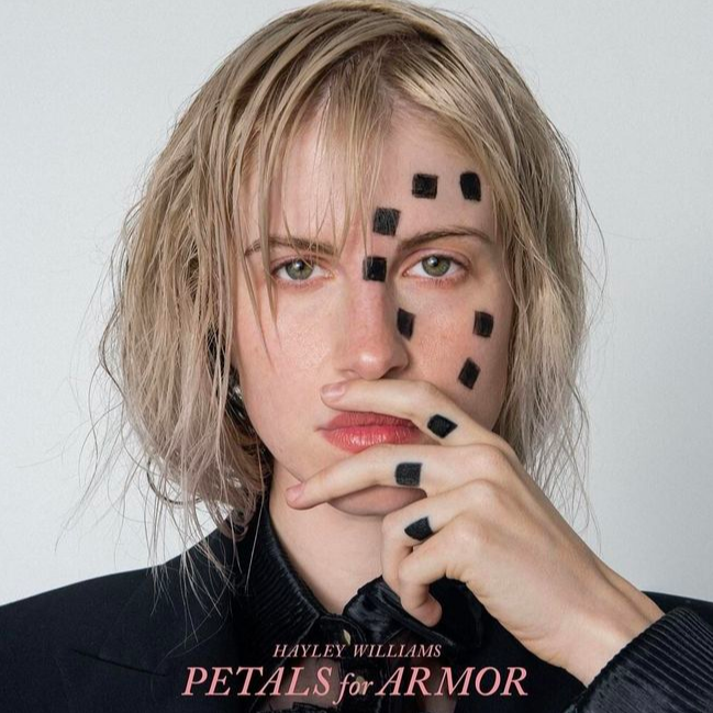 Williams poses for the album artwork of Petals For Armor. Williams originally had Gilberts initials tattooed on her fingers, but after their divorce, she covered them up with the three squares. 