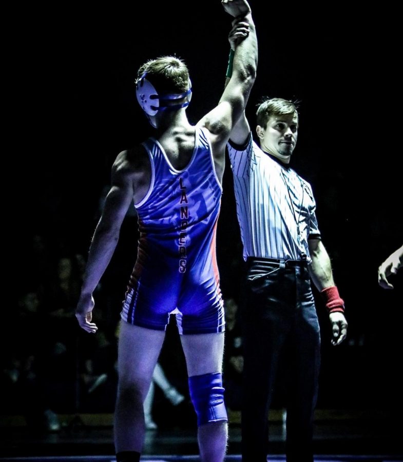 Junior Dylan Barnes wins his match under the light. Barnes works hard to prepare for each wrestling season so he can bring his best at every match.