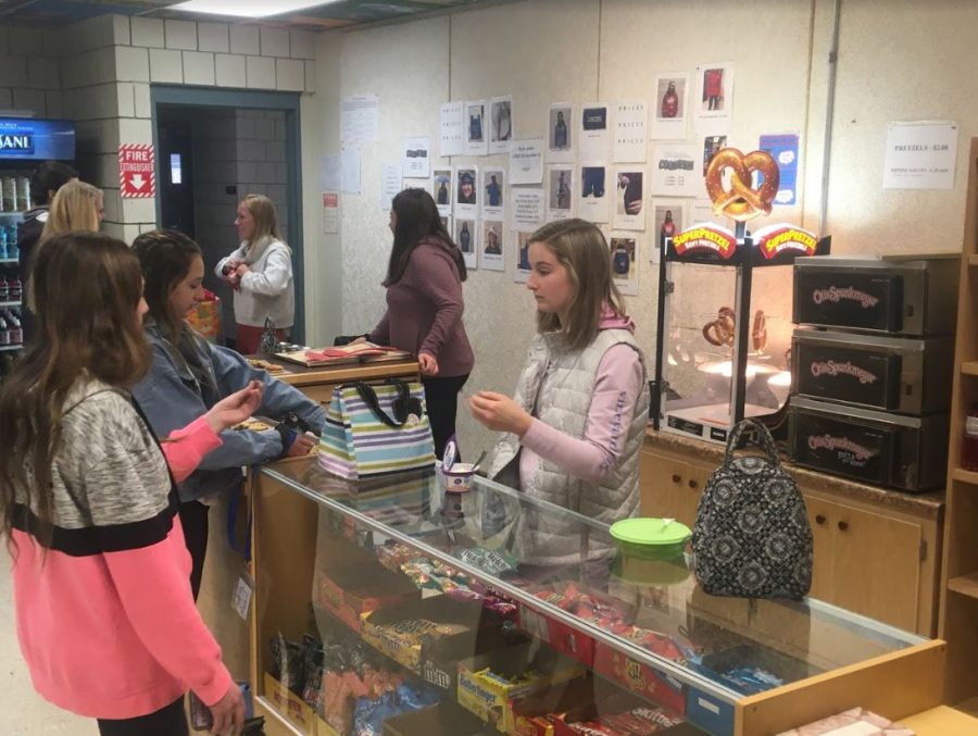 Junior Grace Harpster sells cookies to two freshmen during E Period. The two freshmen paid in cash because the Lancer Locker does not accept ID cards.