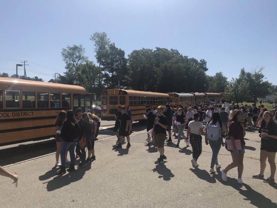 Class of 2023 socialize in front of buses on their orientation day in 2019.