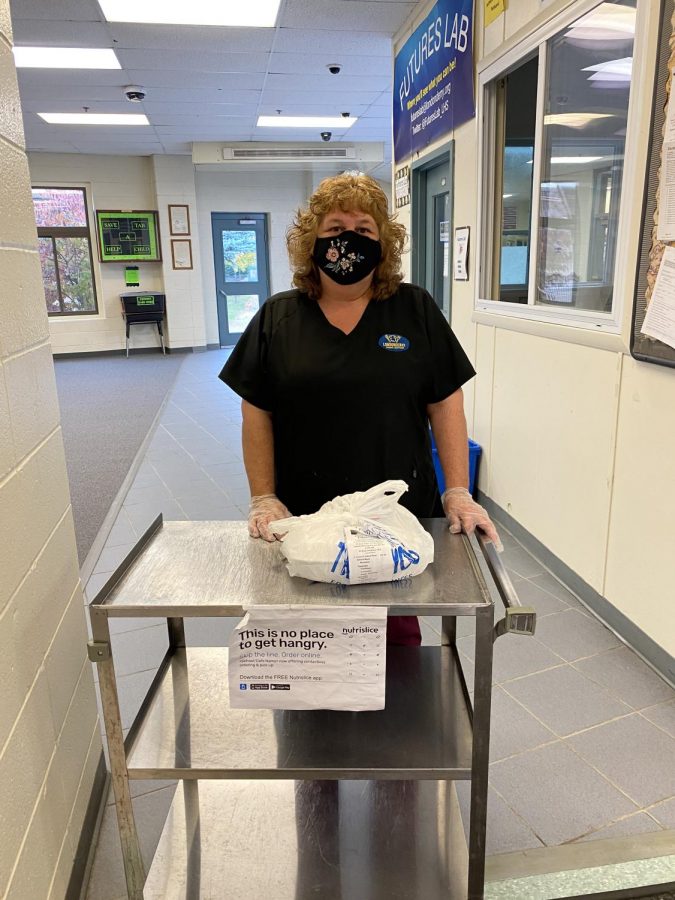Cafeteria staff member Laura Francis gives out the pre-order meals for the E period lunch. Every lunch is packaged with the name of the student on the bag, making it easy for people to find their meals. 