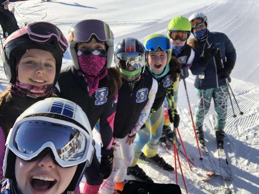 Varsity ski team takes a snap before making practice runs down the mountain. These practice runs help warm up these skiers while up on the cold mountain top.

