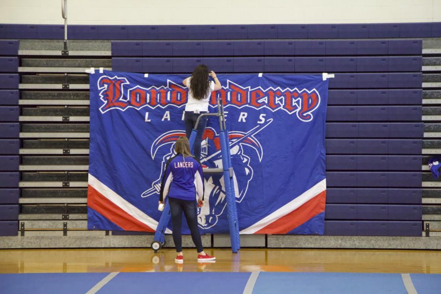 Senior Amara Cote sets up a “Londonderry Lancers” banner in preparation for the pep rally. Photo by Sean OMara 