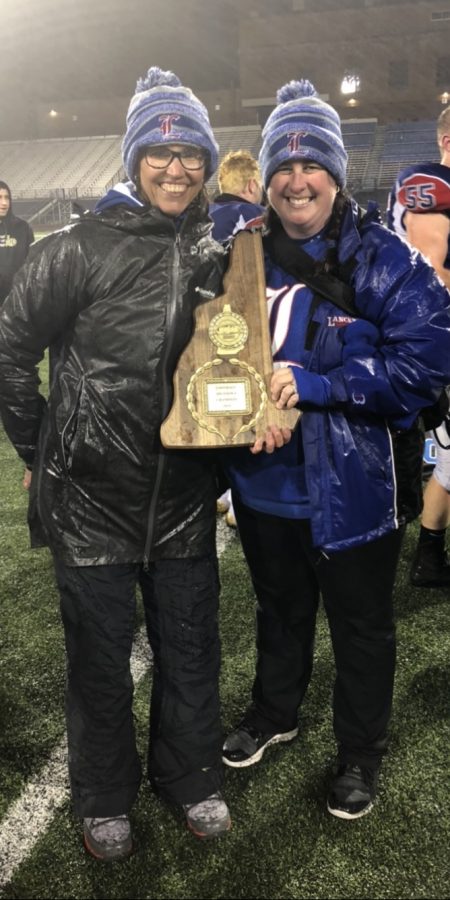Trainers Meghan Powers and Michelle-Hart Miller stand on the sidelines at the Division I State Championship football game in 2019 after the Lancers took the win.