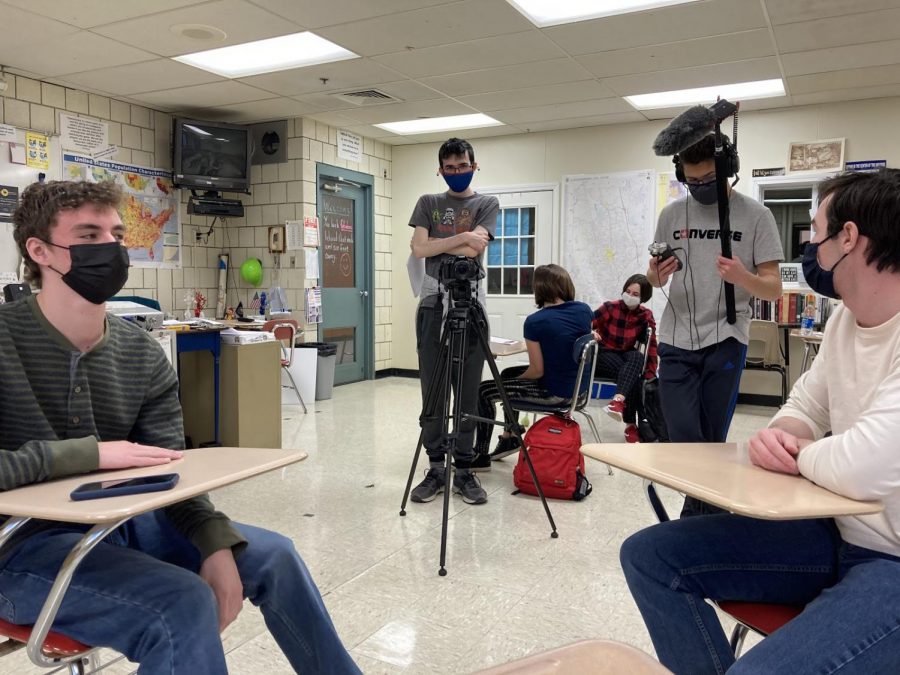 Cinematography and audio directors Garrett Calusdian (left midground) and Spencer McIntyre (right midground) set up a shot for “Facade”. This picture features some of the cast and crew of the film during production, with actors Sean O’Mara (right) and Josh Truesdale (left) in the foreground and extras Annika Suckow (left) and Makenzie Gainey (right) in the background.