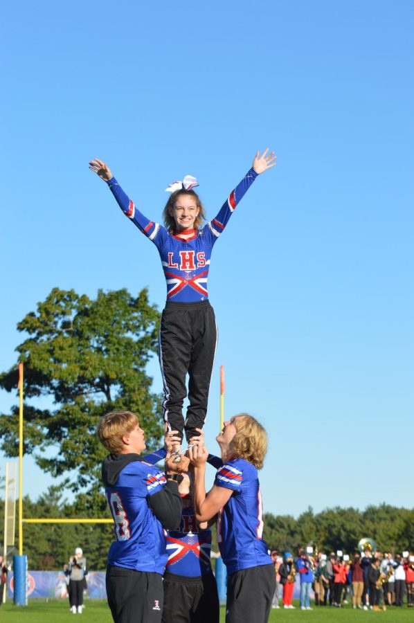 Members of the football team lift the cheerleaders during their surprise routine.
