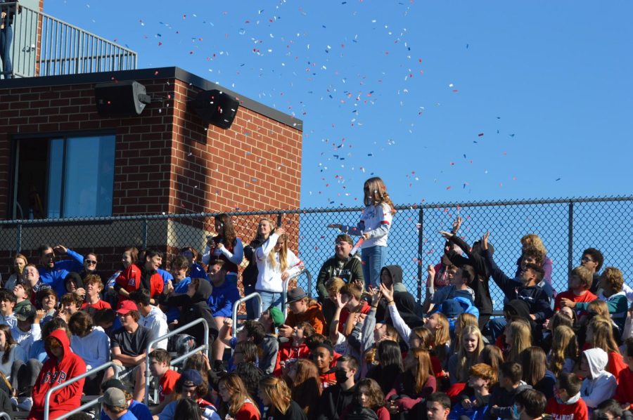 Pep Rally aides shoot off confetti cannons.
