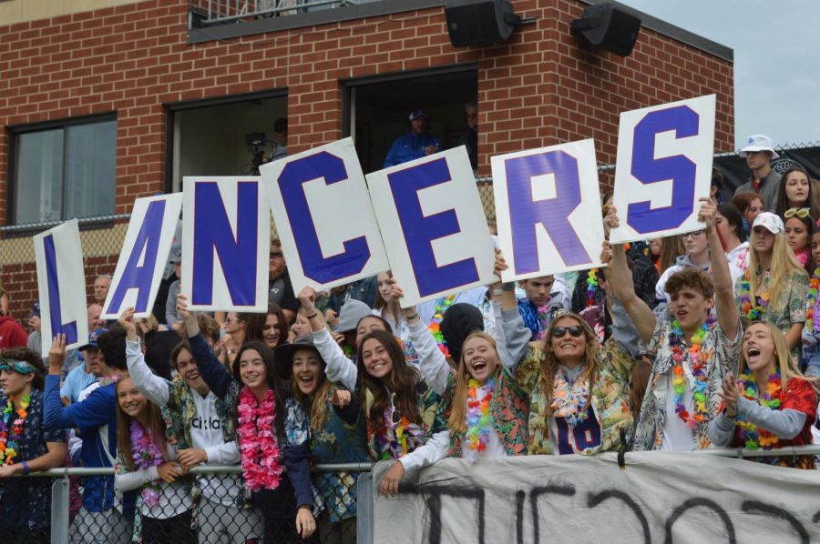 Gators hold up letters spelling out “LANCERS” during a home game against Alvirne. The letters have now become a staple at home games.