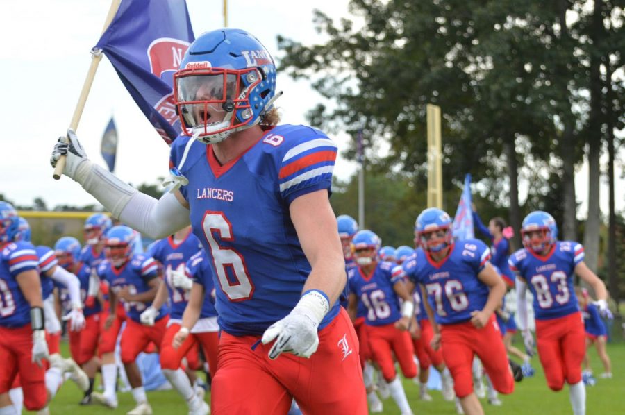 Senior captain Riley Boles leads the team out to anticipating Lancer fans.